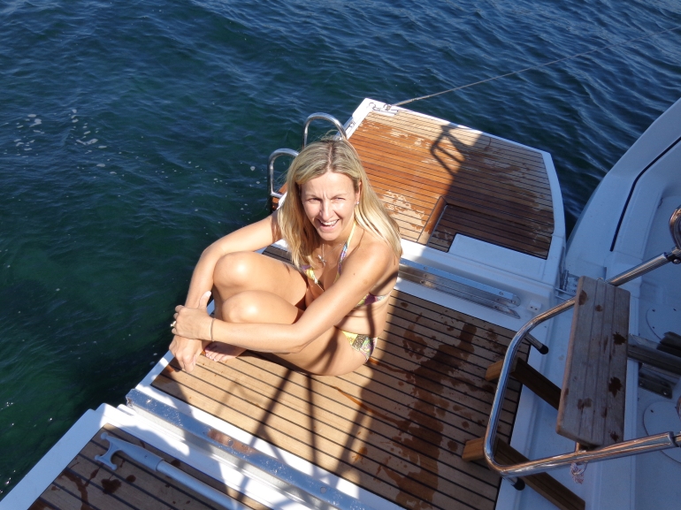 Valerie Toomey relaxes on the drop-down swim platform after taking a refreshing dip in the cool Medateranian Sea.